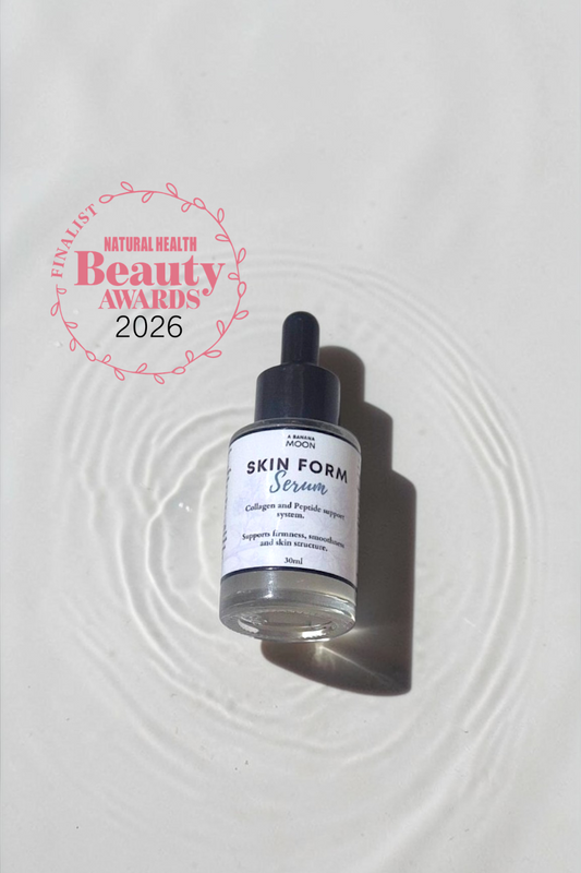 Skincare serum bottle with dropper on a textured white surface, featuring a Beauty Awards 2026 label.